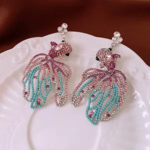 Boucles d'oreilles poisson vintage avec strass scintillants sur une assiette décorative