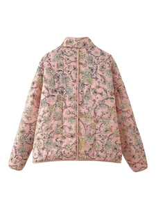 Detail view of pink quilted jacket featuring intricate yellow and white floral patterns