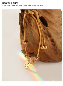 Detail of adjustable 18K gold plated snake chain bracelet with heart charm and zircon stone