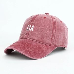 Close-up of vintage washed red baseball cap with white CIA letter embroidery