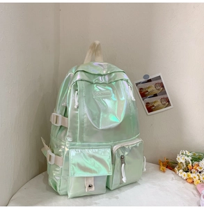 Close-up of holographic light green backpack showing multi-pocket design and iris texture
