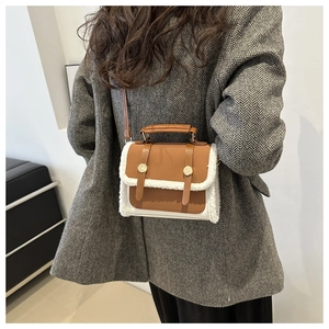Detail of vintage brown leather handbag with faux shearling trim and golden lock