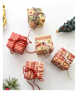 Mini Christmas gift boxes with festive patterns and cotton twine on a white background