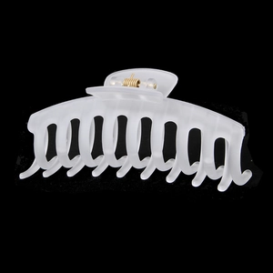 Détail d'une grande pince à cheveux blanc mat avec un mécanisme à ressort en métal doré