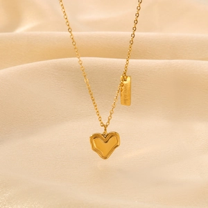 Golden irregular heart pendant necklace with engraved fine bar on silk background