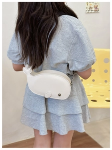 Kid wearing a whale shaped cream PU leather shoulder bag with a stylish metal chain