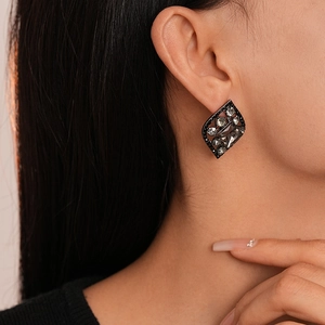 Detail of vintage dark style diamond earring with grey crystal on model's ear
