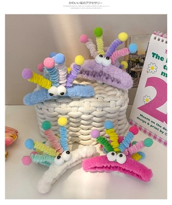 Detail showing four colors of plush monster hair claws with cartoon eyes and colorful balls
