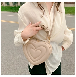 Close-up of heart-shaped quilted bag with ruched handle and fine leather texture