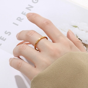 Detaillierte Makroansicht eines minimalistischen goldmattierten Edelstahlrings am Finger