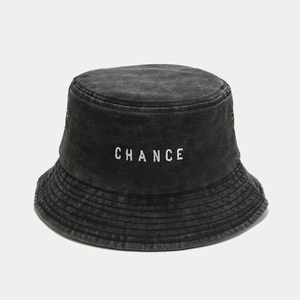 Detail of white CHANCE embroidery on a dark grey washed cotton bucket hat with metal eyelets