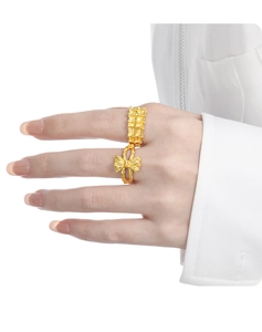 Detailed view of a gold bowknot bamboo ring worn by a model in a professional studio setting