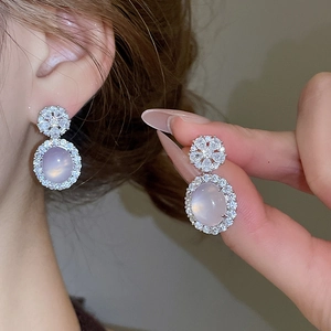 Gros plan de boucles d'oreilles en calcédoine rose avec clous fleur en zircone brillante