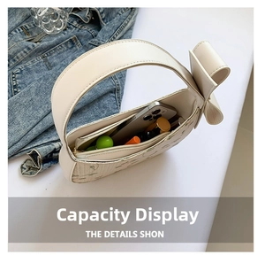 Internal view of the white crescent bag showing capacity for phone and cosmetics