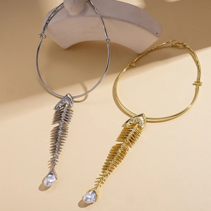 Unique gold and silver fishbone pendant necklaces with pearl details on stone props