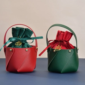 Detail of red and green leather Christmas gift bags with velvet liners and ribbon bows