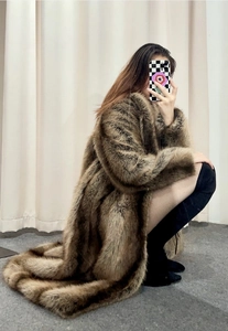 Detail of a long faux fur coat with dark brown animal print texture and large lapels