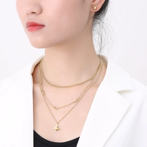 Layered gold titanium butterfly and heart necklace with matching earrings on model