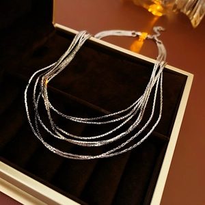 Macro shot of silver multi-layer snake bone necklace in a velvet jewelry gift box