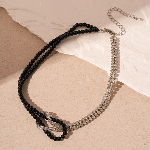 Detail of double-layer necklace with black crystal beads and silver rhinestone chain knot