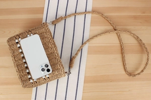 Détail du sac tissé avec perles et téléphone pour référence de taille