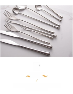 Macro view of mirror-polished 304 stainless steel cutlery set on marble surface