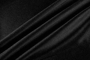 Macro shot of black knit fabric texture showing fine weave patterns and soft drape folds