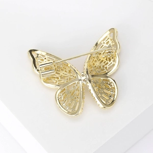 Detailed back view of golden butterfly brooch with secure pin clasp and hollow craftsmanship