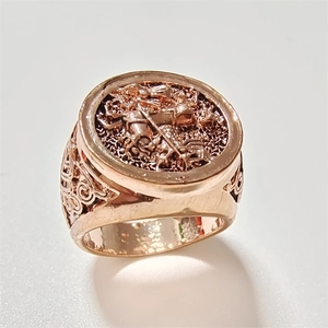 Close-up of vintage rose gold signet ring with Saint George dragon relief carving