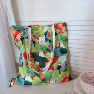 Détail du sac fourre-tout en toile imprimé avec motifs colorés de chats et forêt