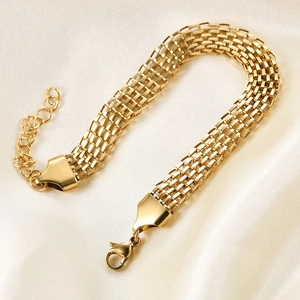 Detail of 18K gold braided 8mm wide chain bracelet with lobster clasp on silk background