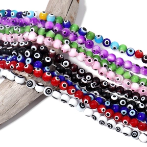 Close-up of colorful millefiori evil eye glass beads on a natural wood surface for DIY jewelry