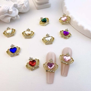 Colorful crown and heart crystal nail art charms on display for manicures