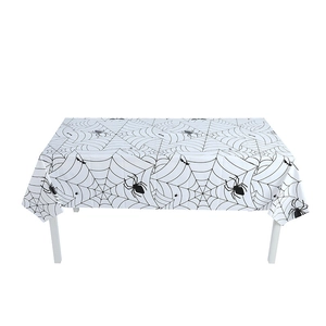 Close-up of Halloween tablecloth with black spider web and spider patterns on white