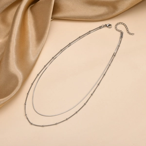 Detail of silver double layer necklace featuring sleek snake chain and delicate beads