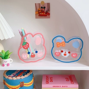 Cute cartoon animal acrylic pen holders in pink and blue on a bright aesthetic desk