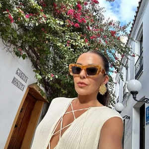 Elegant sleeveless knit dress paired with tortoise sunglasses and golden sunflower earrings