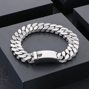 Close-up of silver Cuban link bracelet with iced-out rhinestones on black gift box