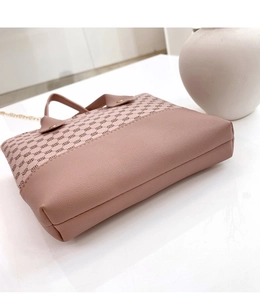 Detailed side view of pink monogrammed handbag with leather trim and gold chain strap