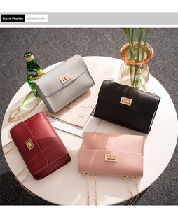 Flat lay of small crossbody chain bags in gray, black, burgundy, and pink with gold clasps