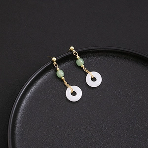 Detailed view of green beads and white rings on vintage water drop tassel earrings