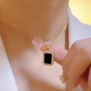 Gold rectangular pendant necklace with black center and small sparkling crystals