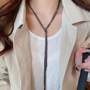 Detail of dark gunmetal multi-layer chain necklace with elegant knotted tassel design