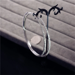Close-up of oversized silver hoop earrings with sparkling rhinestones on a display