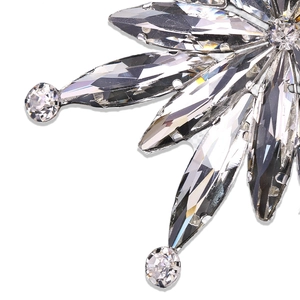Macro shot of luxury snowflake brooch showing sparkling rhinestones and silver metal finish