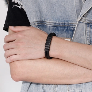 Close-up of a double-layered black braided leather bracelet with metal buckle on wrist