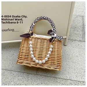 Detail of hand-woven rattan handbag with pearl chain strap and houndstooth scarf handle