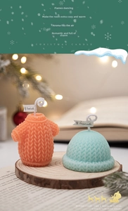 Detailed close-up of knitted sweater and hat scented candles for Christmas decor