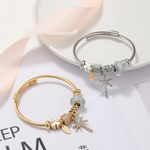 Detail view of gold and silver DIY stainless steel bracelets with starfish and clover charms