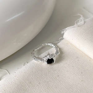 Close-up of S925 sterling silver open ring with textured surface and black zircon gem
